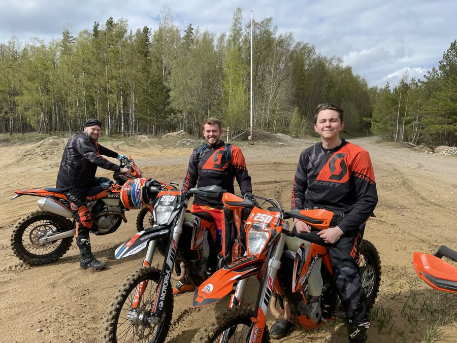 Two of the team with enduro bikes on a dirt track